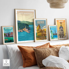 Framed travel poster prints including West Vancouver, Rome, Madrid, and Amsterdam, displayed above a cozy sofa.