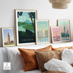 Rwanda travel poster print featuring mountain gorillas, displayed among other city art prints in a cozy living room setting.