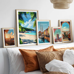 Seychelles Beach Print: Elegant Island Escape showcased among other travel-themed art prints on a cozy bed.