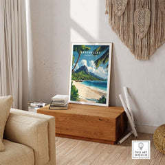 Seychelles Travel Poster - Beach Scene displayed in a cozy living room with a wooden table and lush decor.