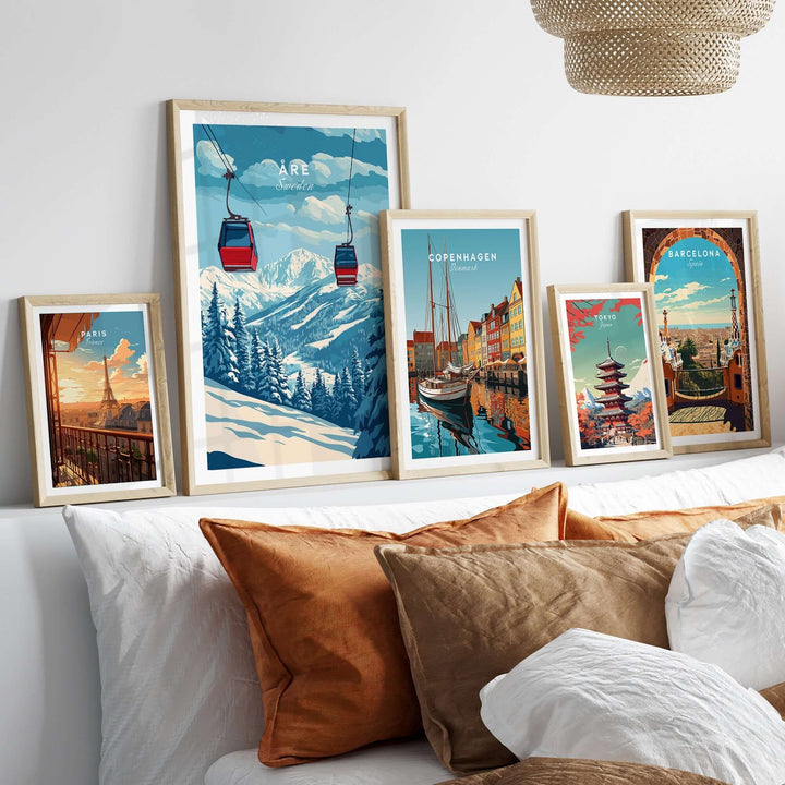 Framed ski art prints featuring Åre, Sweden, and other cities, displayed on a cozy sofa with decorative pillows.