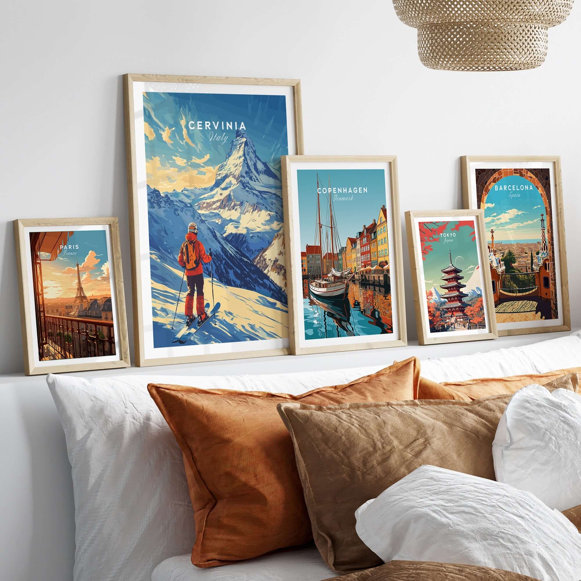 Ski print of Cervinia, Italy displayed among art prints on a stylish wall above a cozy bed with decorative pillows.