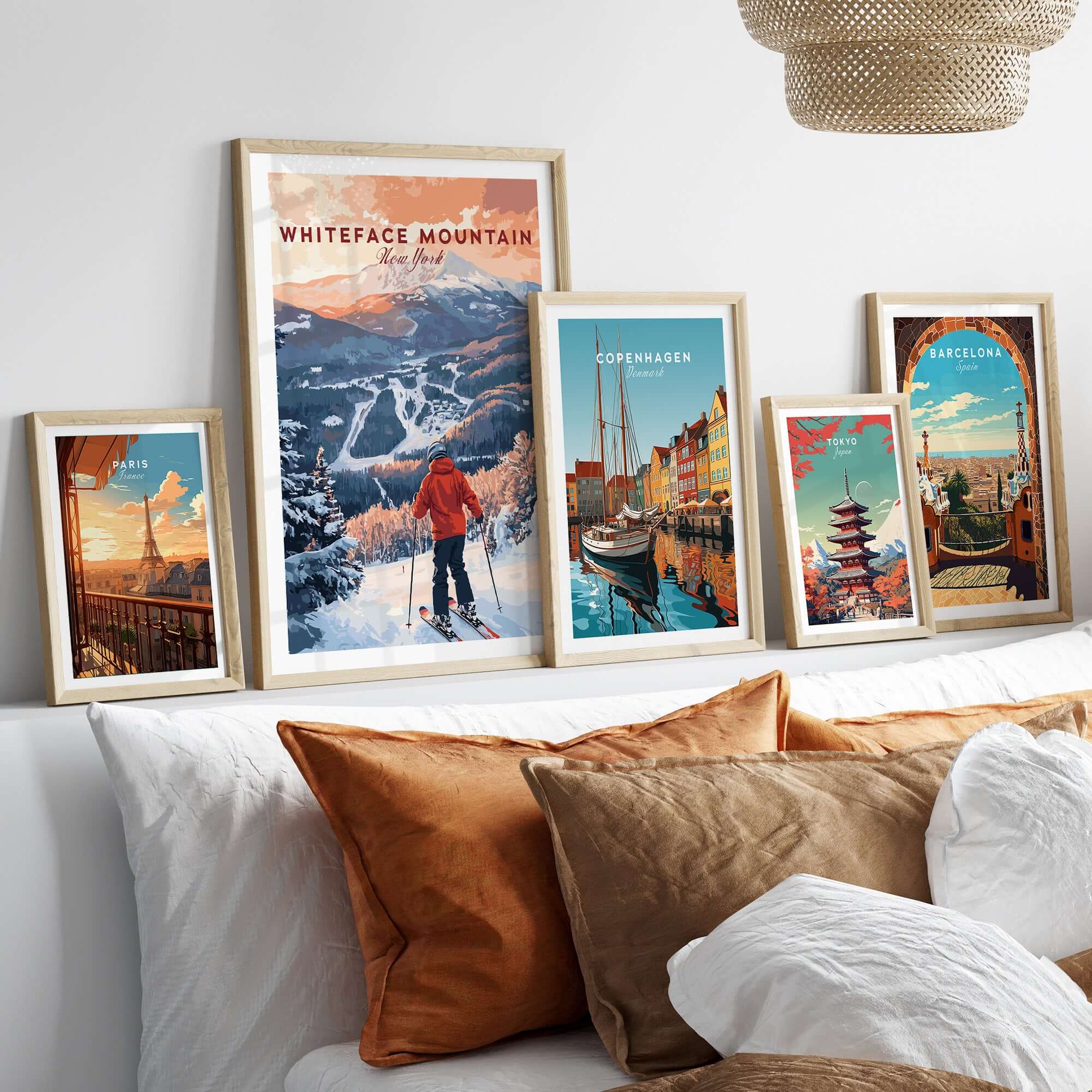 Collection of ski and travel prints including Whiteface Mountain New York, displayed on a modern wall above a cozy couch.