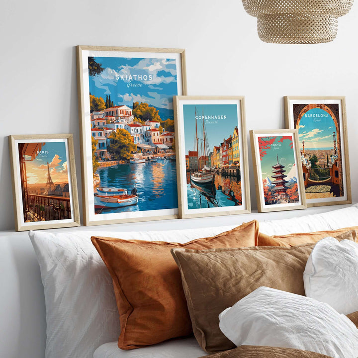 Collection of travel art prints including Skiathos, Copenhagen, and Barcelona displayed above a cozy couch.