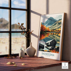Snowdonia National Park Poster displayed on a wooden shelf with scenic landscape and vibrant colors.