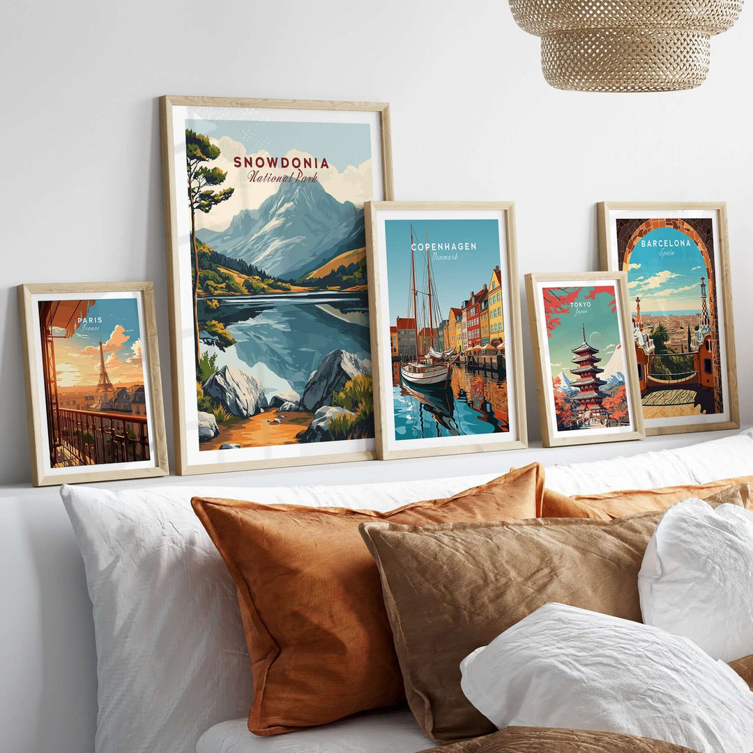 Snowdonia National Park travel print displayed among framed art prints on a stylish sofa, showcasing vibrant landscapes and travel destinations.