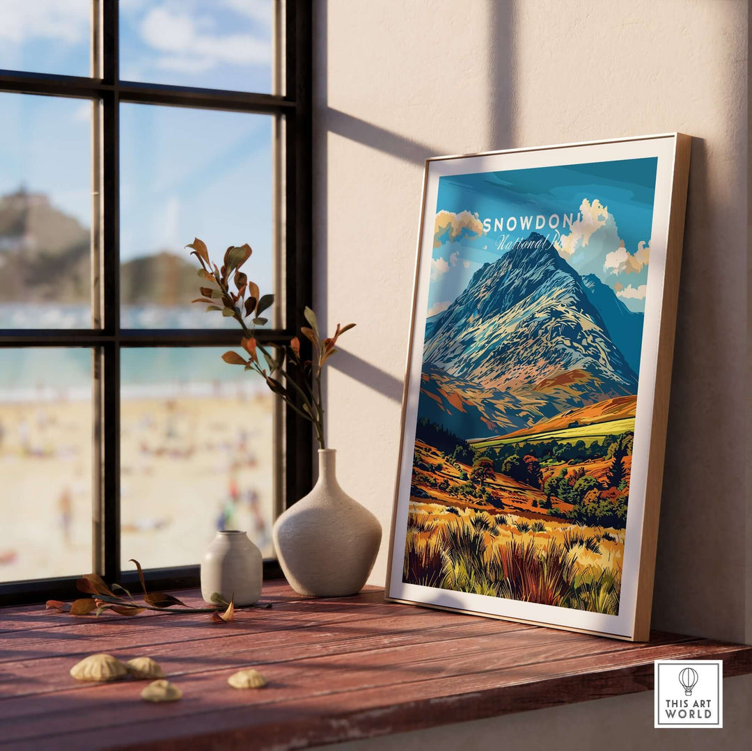 Snowdonia National Park poster on a wooden table by a window, showcasing vibrant mountain scenery and nature's beauty.