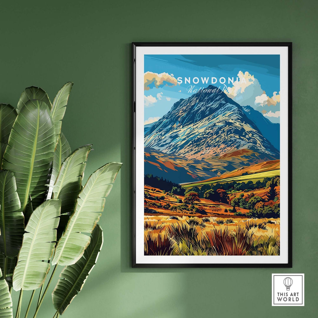 Colorful poster of Snowdon mountain in Snowdonia National Park, Wales, displayed on a green wall with indoor plants.