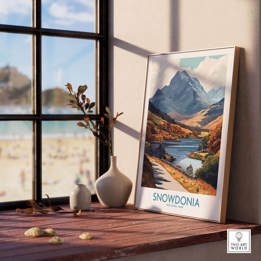 Snowdonia National Park wall art print displayed on a wooden surface near a window, showcasing picturesque landscapes.