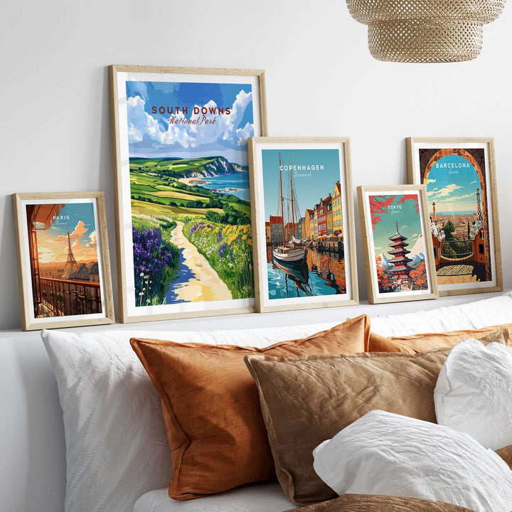 Display of framed travel posters including South Downs National Park, Copenhagen, and Barcelona in a cozy living room setting.