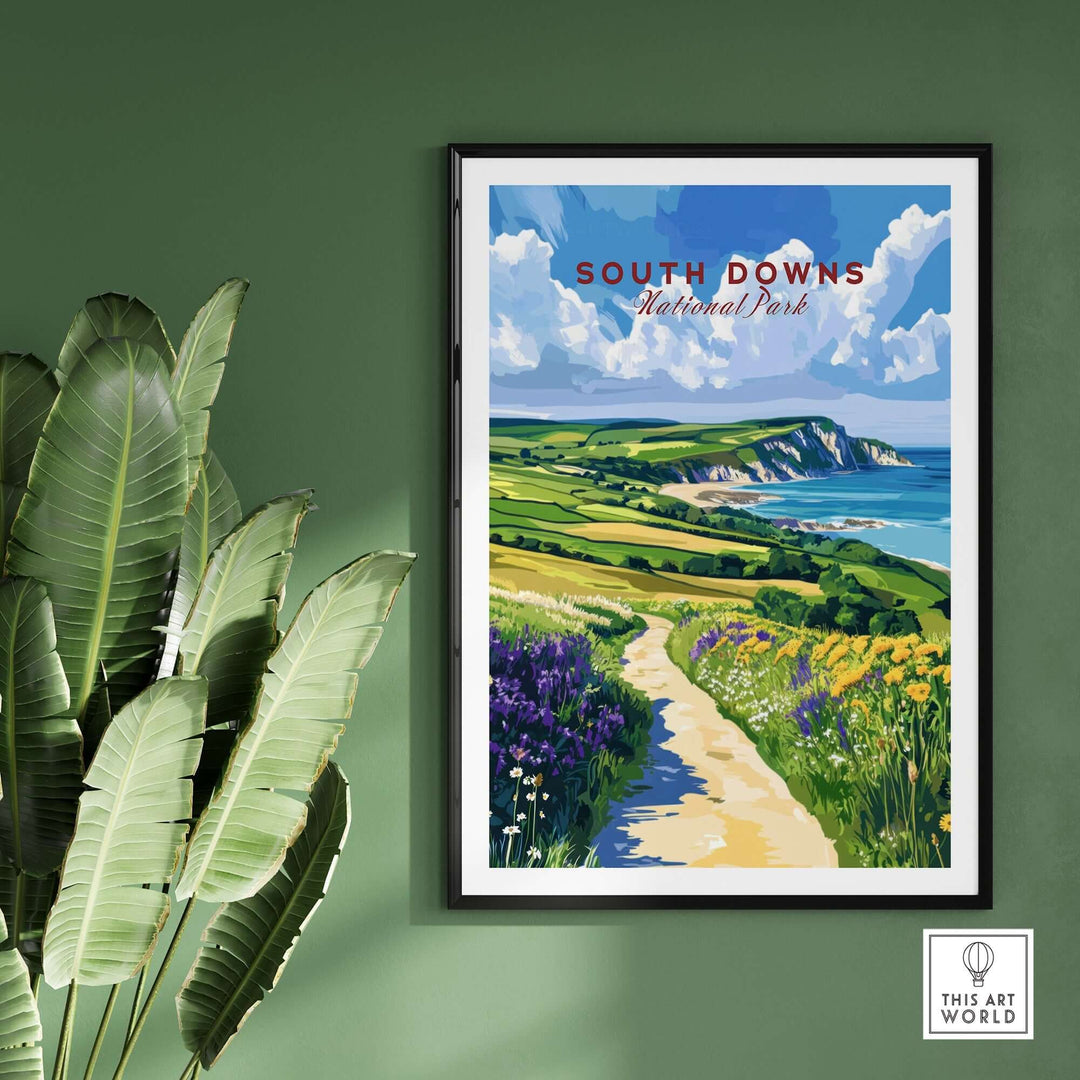 South Downs National Park poster featuring vibrant cliffs and lush fields, displayed on a green wall with plants.