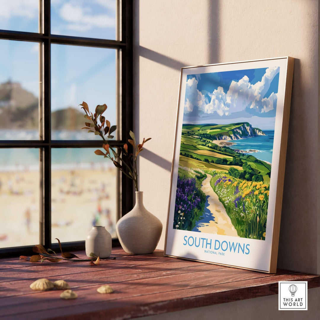 South Downs National Park poster displayed on a windowsill, showcasing iconic coastline and vibrant landscapes of England.