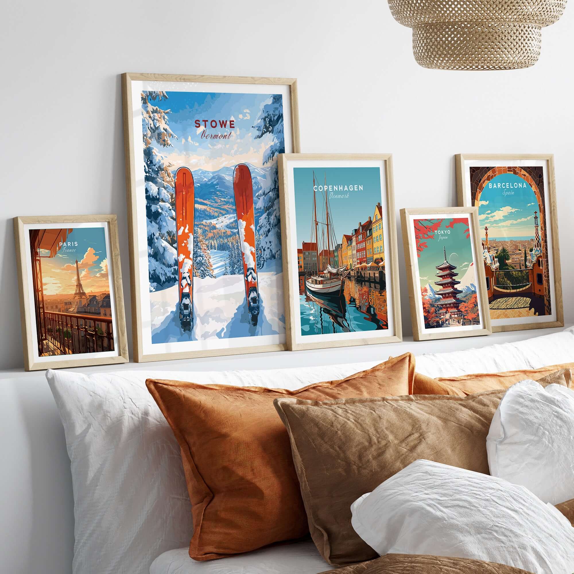 Stylish decor featuring framed Stowe Vermont ski print and travel posters on a cozy bed with brown and white pillows.