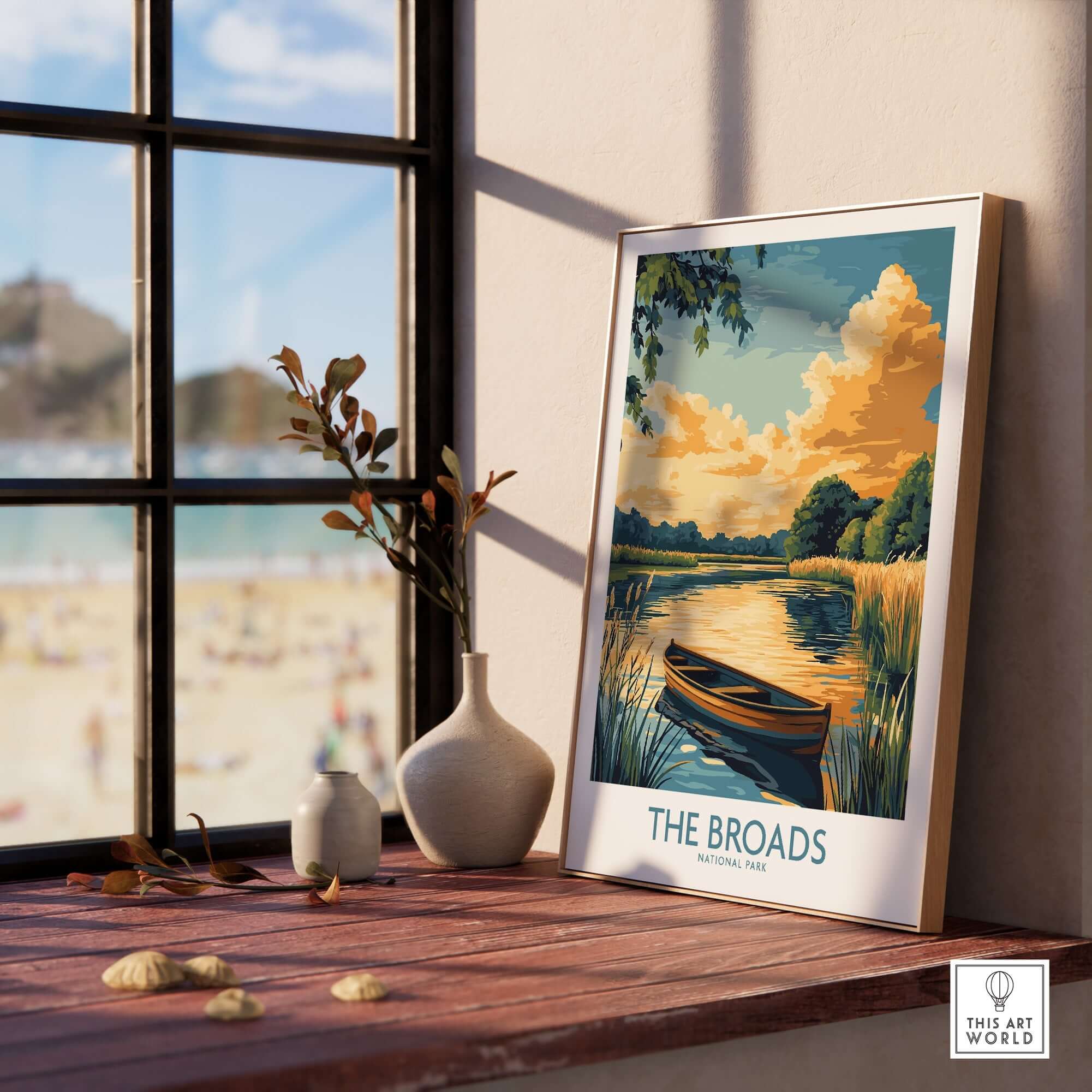 The Broads National Park Art Print displayed on a wooden table near a window, capturing the serene landscape.