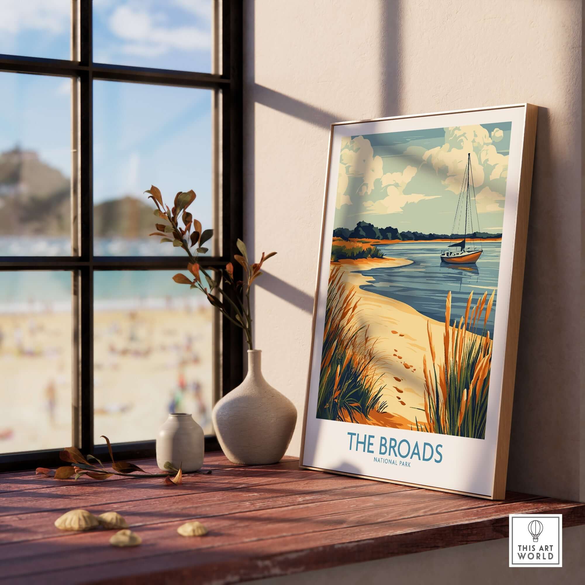 The Broads National Park Poster displayed on a windowsill with a serene landscape and a boat.
