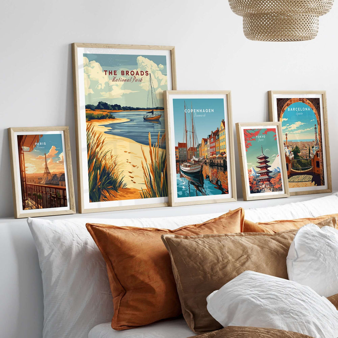 Framed prints of The Broads National Park and cityscapes on a stylish shelf with decorative pillows in a cozy living space.