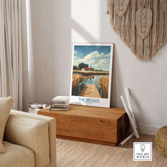 The Broads National Park Travel Poster featuring serene waterways and vibrant landscapes in a cozy interior setting.