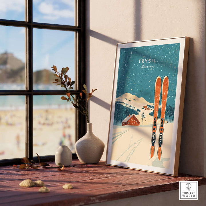 Trysil ski wall art print featuring vintage skis and a snowy landscape, displayed on a wooden table by a window.