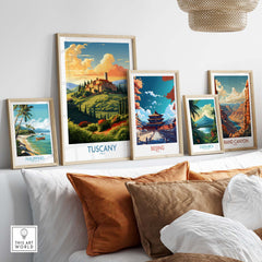 Framed travel posters of Tuscany, Beijing, Costa Rica, and the Grand Canyon displayed in a cozy living room setting.