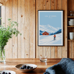 Val-d'Isère Poster France featuring a skier in front of snowy mountains and a cozy chalet.