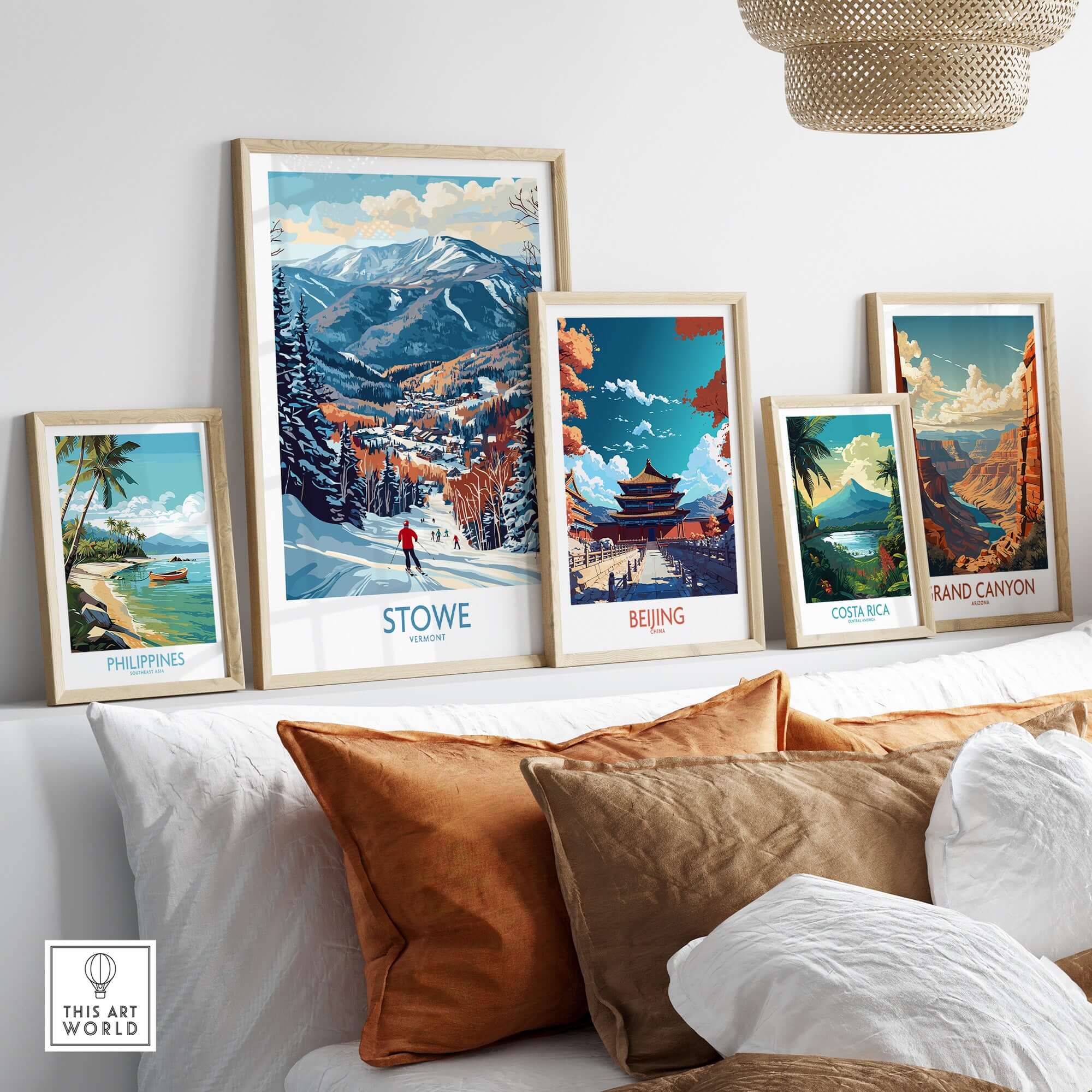 Framed travel art prints of Stowe, Beijing, Costa Rica, Grand Canyon, and the Philippines displayed on a cozy living room wall.