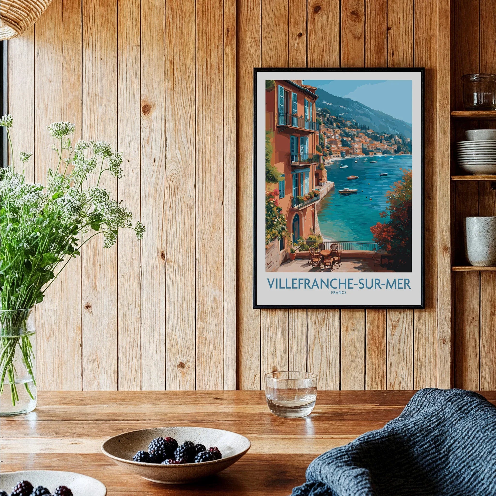 Villefranche-sur-Mer travel poster art in black frame displayed in cozy wooden kitchen setting
