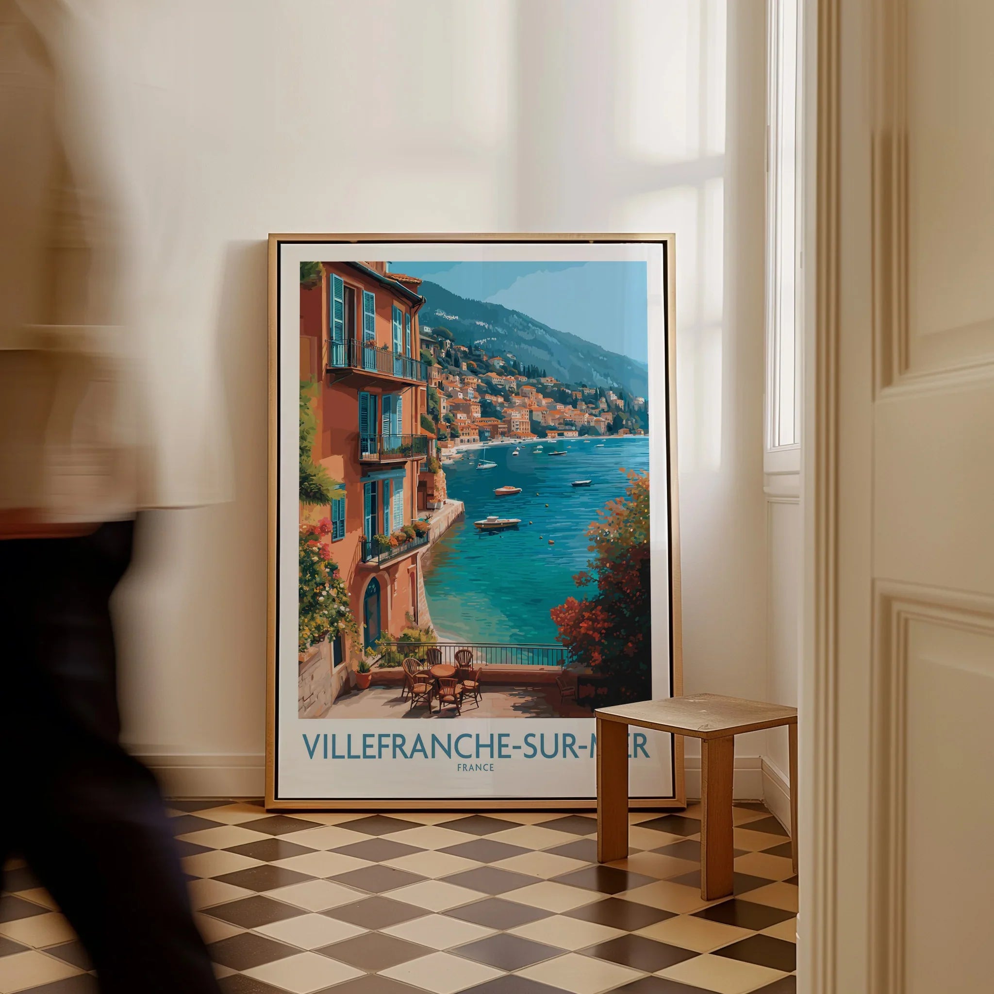 Framed Villefranche-sur-Mer travel poster with coastal art on floor in bright hallway