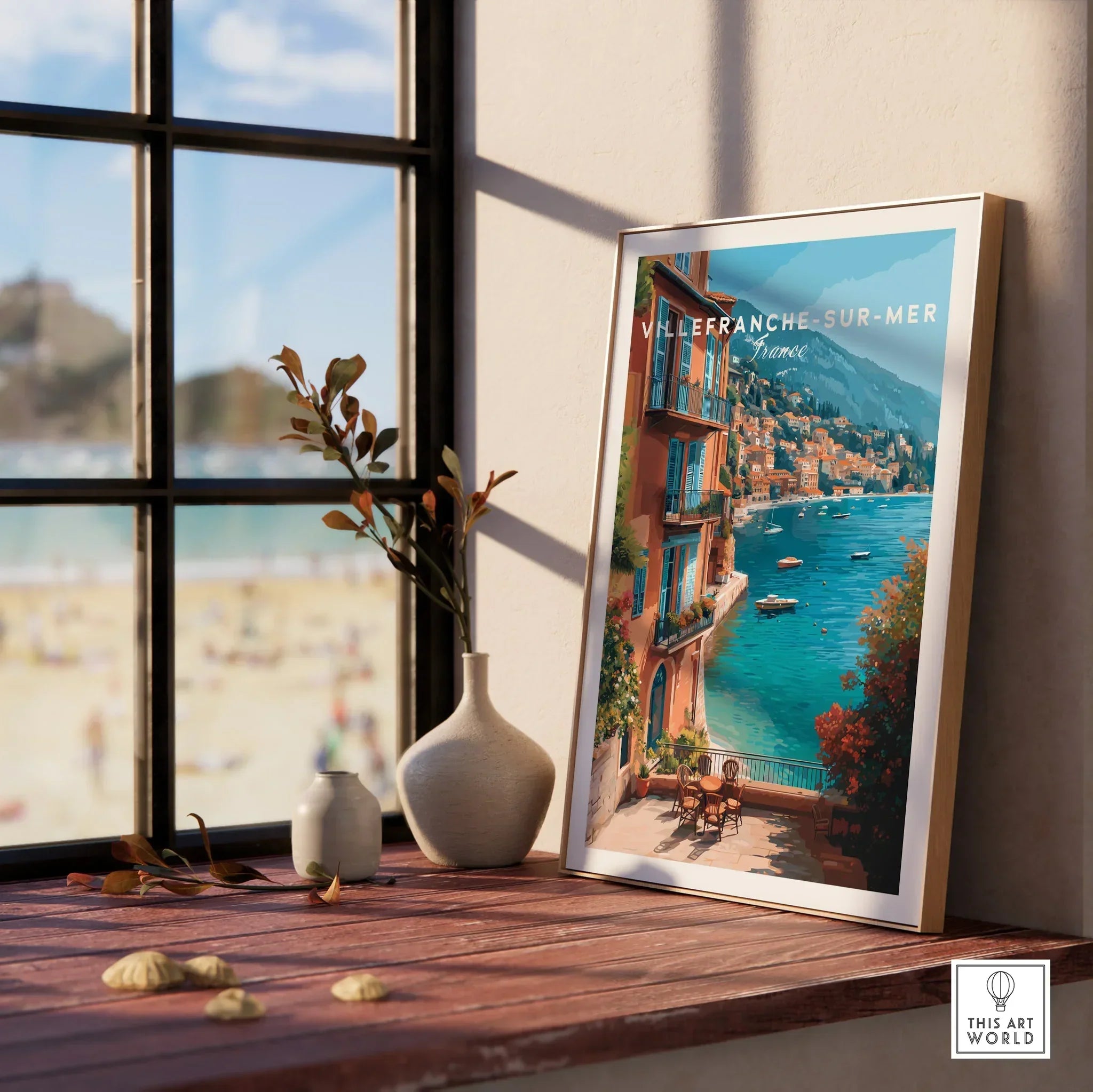 Framed Villefranche-sur-Mer travel poster on wooden windowsill with vases and beach view