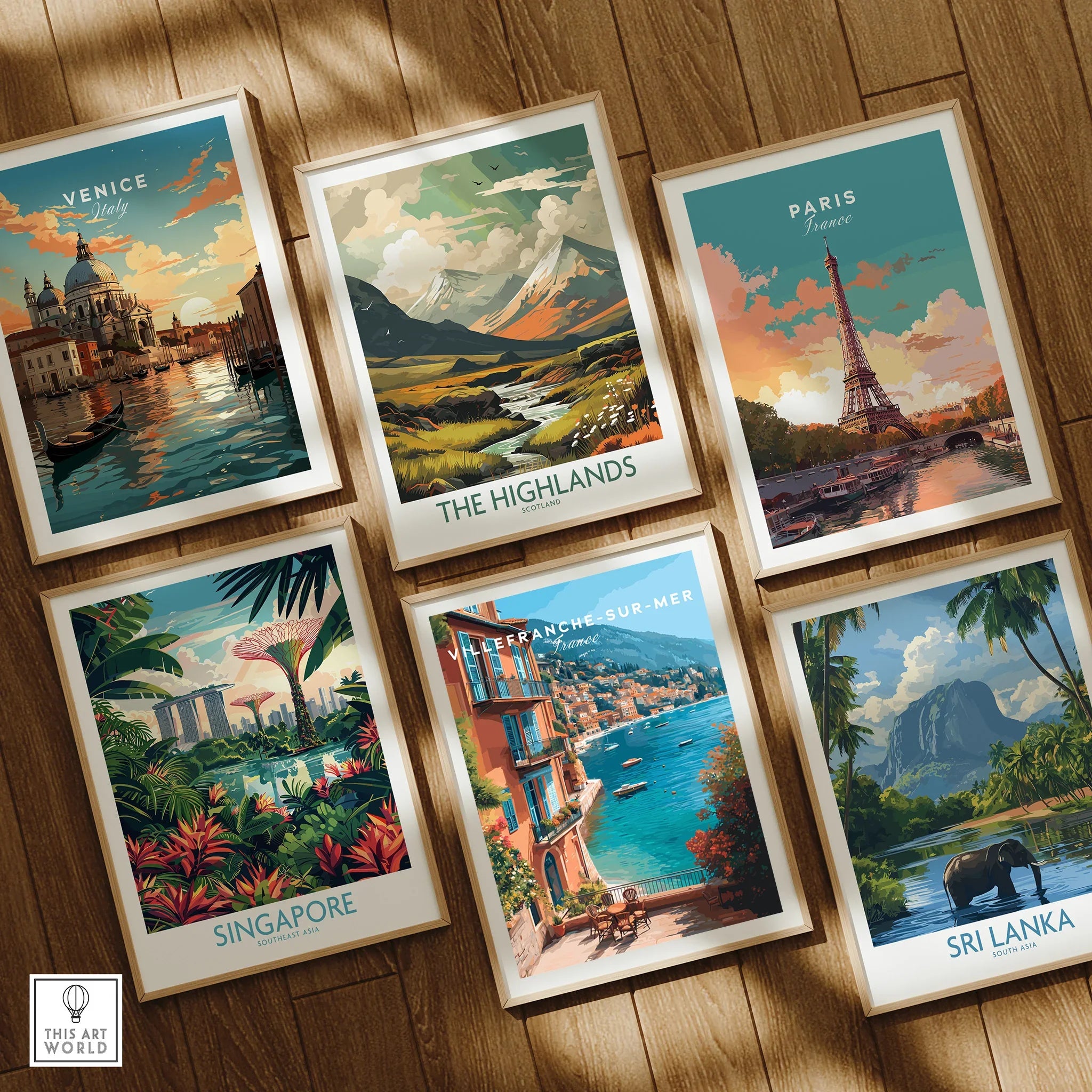 Set of six framed travel art prints featuring Venice, Paris, Highlands, Singapore, Villefranche-sur-Mer, and Sri Lanka, displayed on a wooden floor.