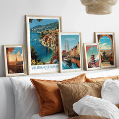 Set of five framed travel posters featuring city and national park art above a bed