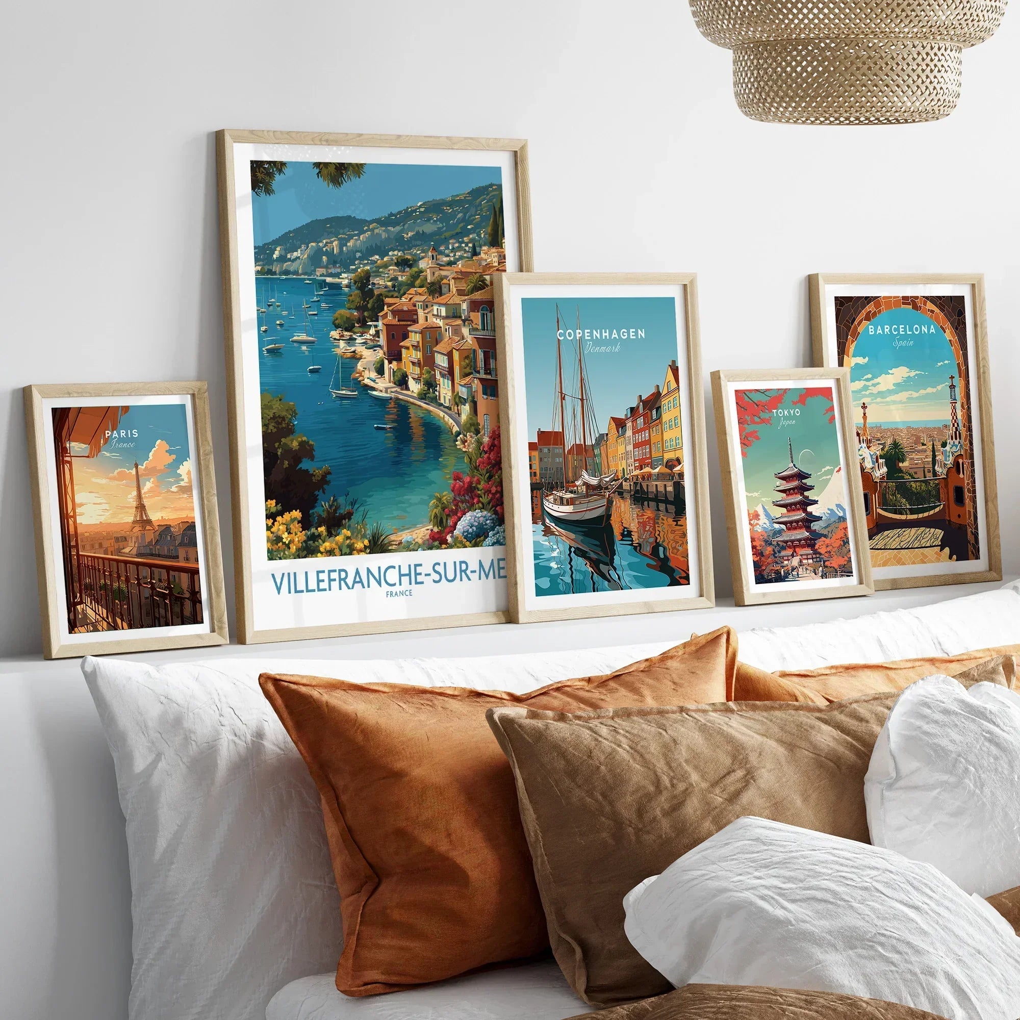 Set of five framed travel posters featuring city and national park art above a bed