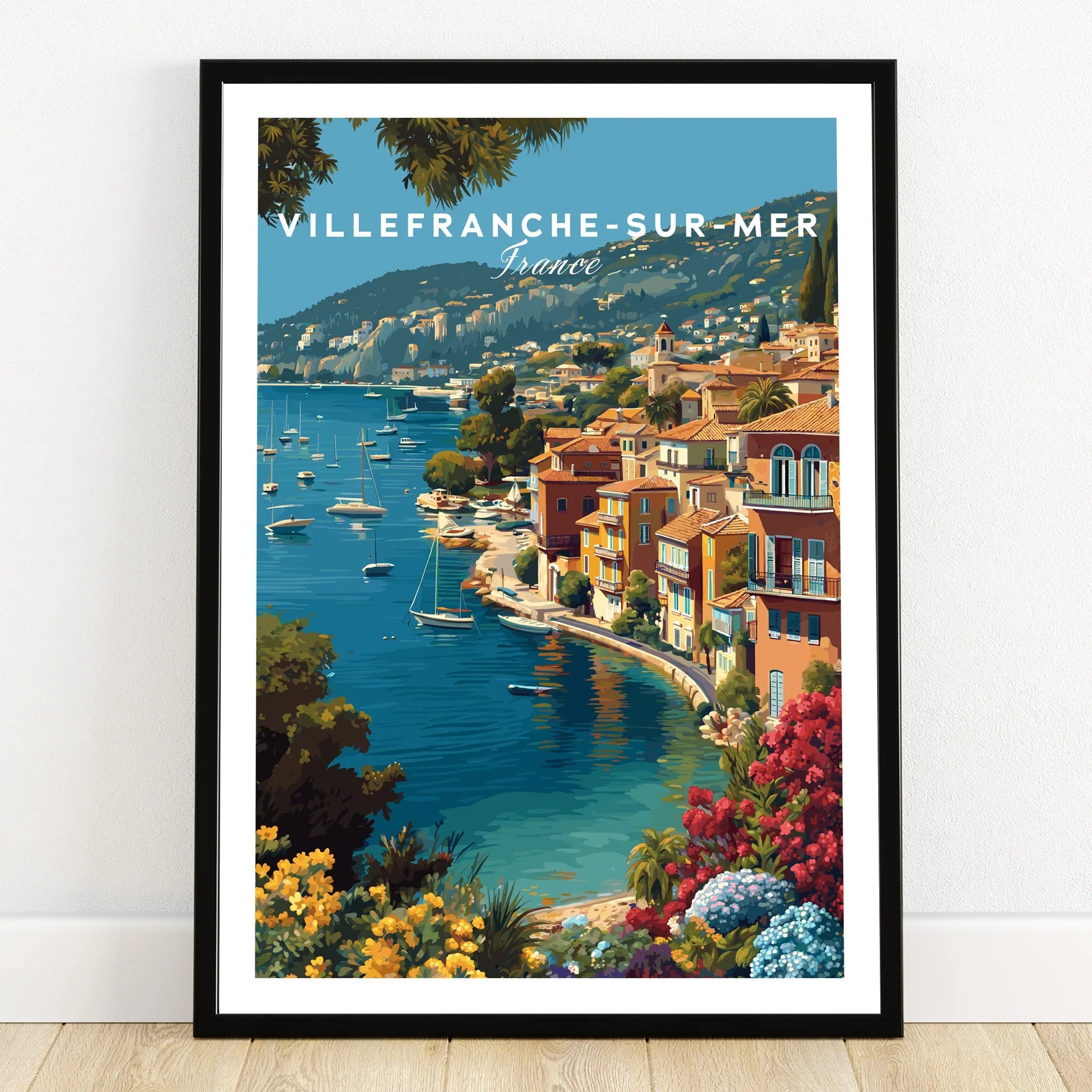 Villefranche-sur-Mer art print in black frame on wooden floor, coastal travel poster