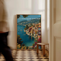 Framed Villefranche-sur-Mer travel poster with colorful coastal art on checkered floor, man walking past
