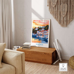 Wall Art Print of Skiathos Greece displayed in a stylish living room, featuring vibrant sunset colors and coastal scenery.
