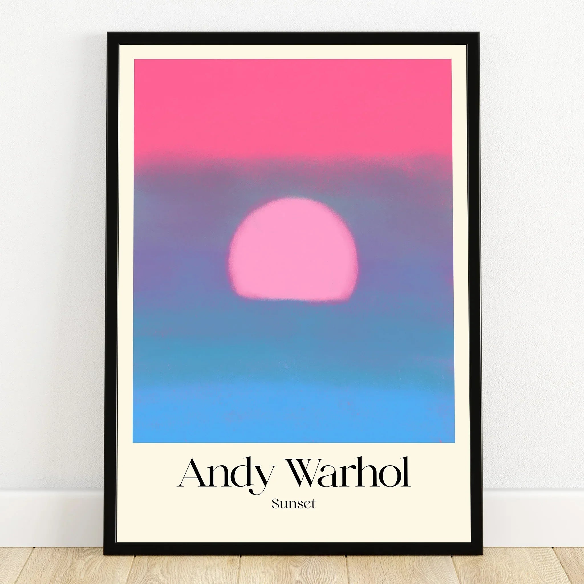 Framed Andy Warhol sunset print with bold pink sun and soft blue gradient wall art