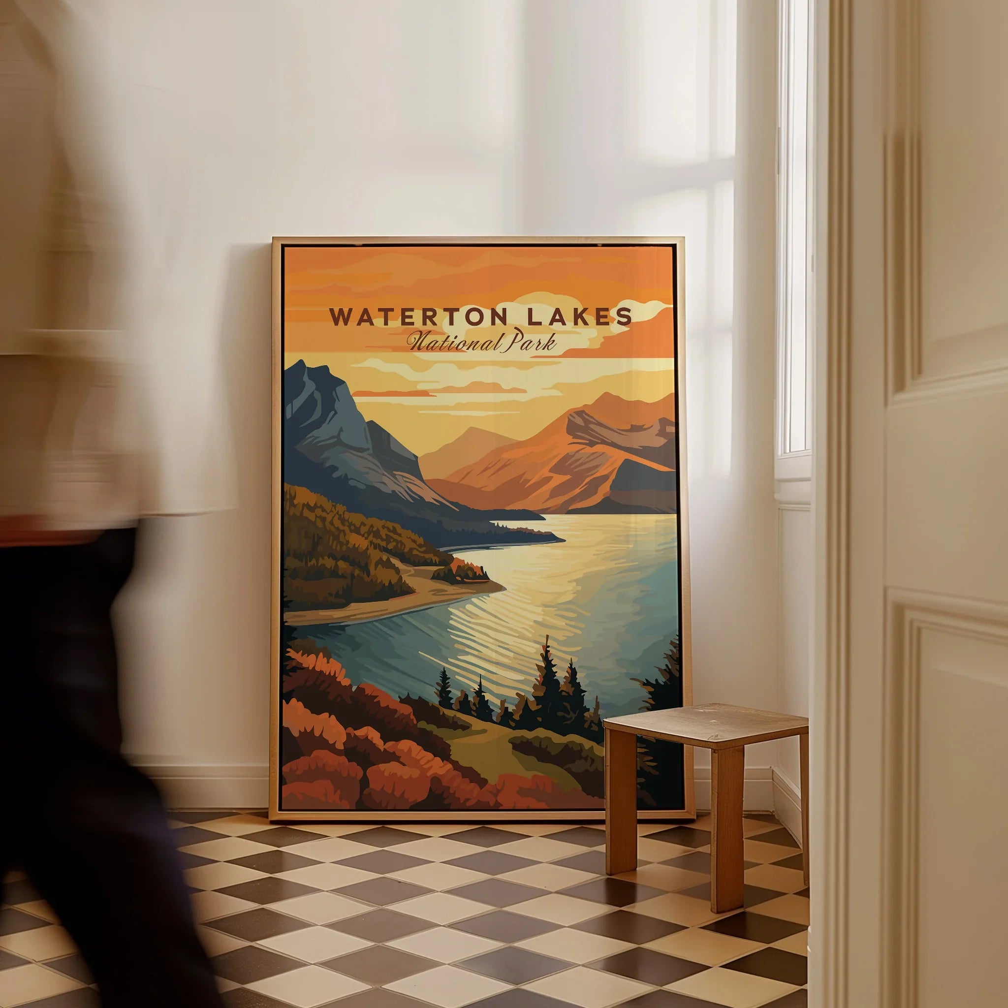 Framed Waterton Lakes National Park travel poster on floor, man walking past in hallway.