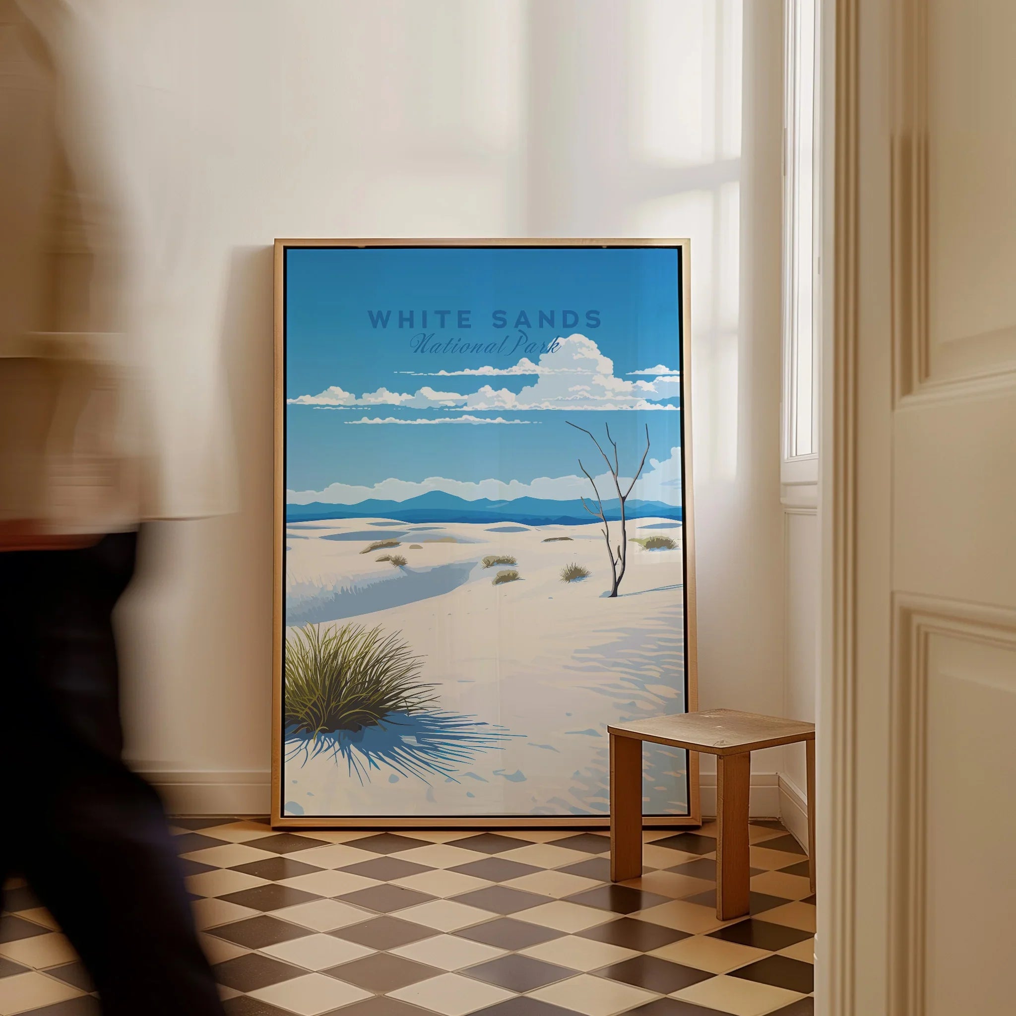 Framed White Sands National Park travel poster on floor in bright room with checkered tile