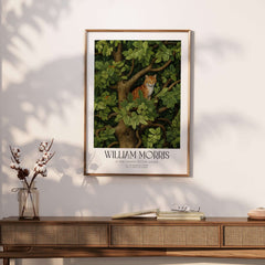 William Morris Ginger Cat in Tree Botanical Art Print - Foliage Poster displayed on a wall above a wooden table.
