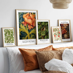William Morris Orange Bloom Swirling Leaves Art Print - Botanical Poster displayed among other floral prints on a stylish shelf.