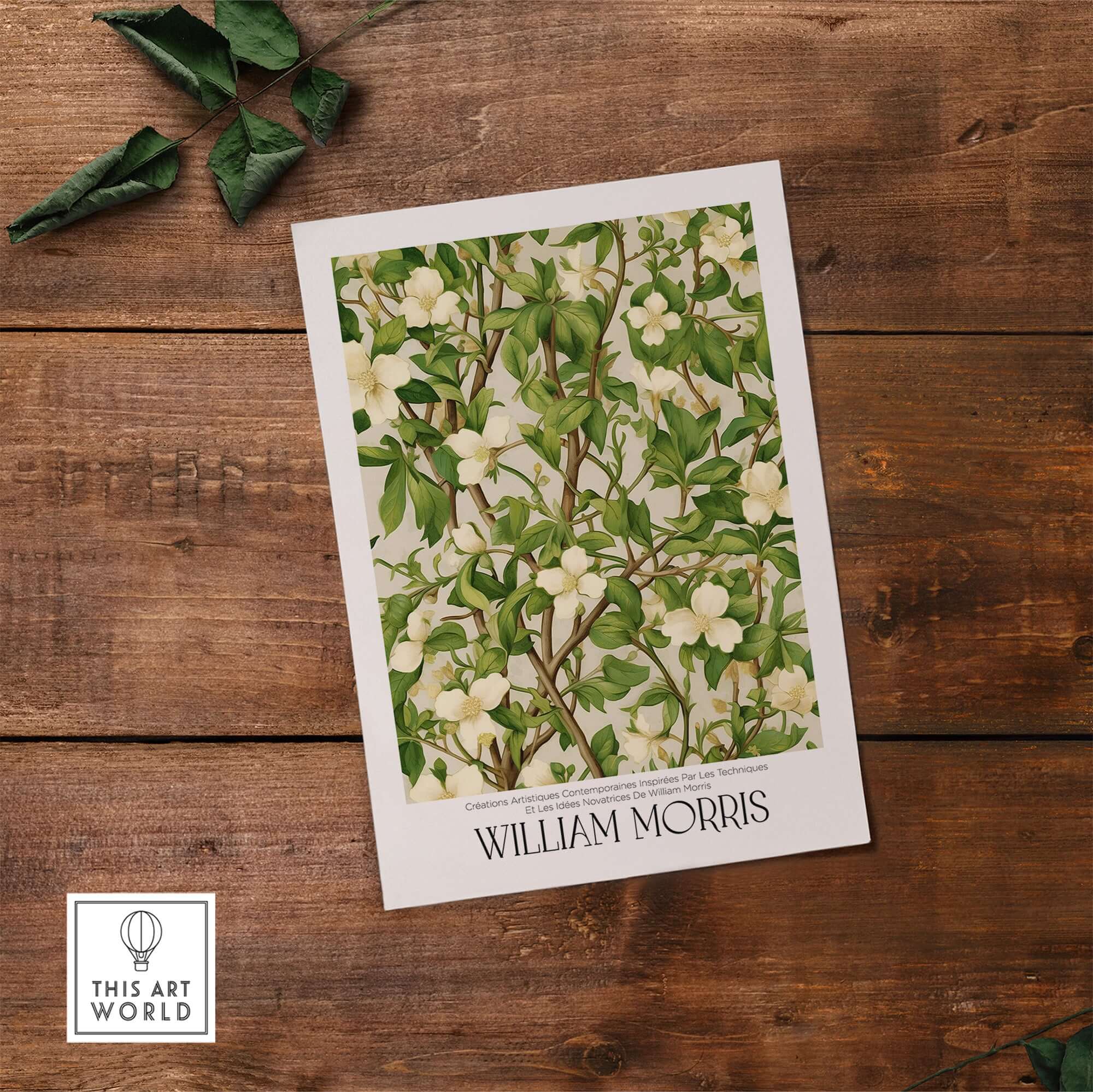 William Morris Prints - White Blossom Branch Art Print - Exhibition Poster on a wooden surface with green leaves.