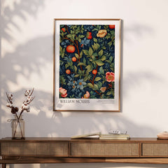 William Morris William Morris Fruit and Floral Vine Art Print - Dark Botanical Poster framed on a wall above a wooden table.