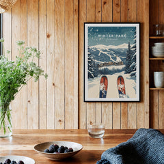 Winter Park Travel Poster - Colorado displayed in a cozy home setting, featuring snowy mountains and ski prints.