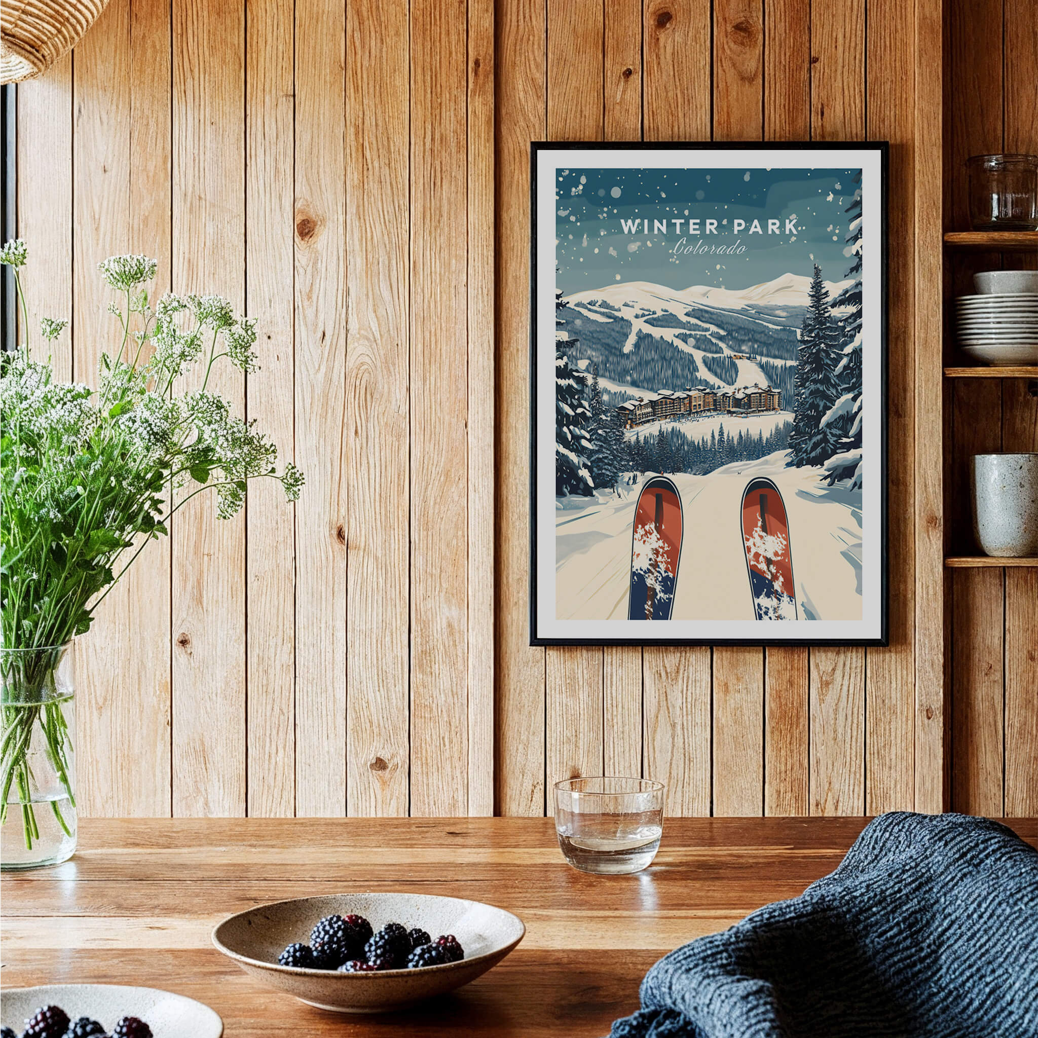 Winter Park Travel Poster - Colorado displayed in a cozy home setting, featuring snowy mountains and ski prints.