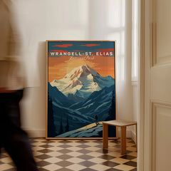 Framed Wrangell-St. Elias National Park poster with mountain artwork on floor, person walking by