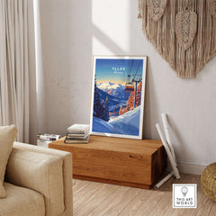 Ylläs Ski Lift poster in a cozy living room setting, showcasing snowy mountains and a ski lift at sunset.