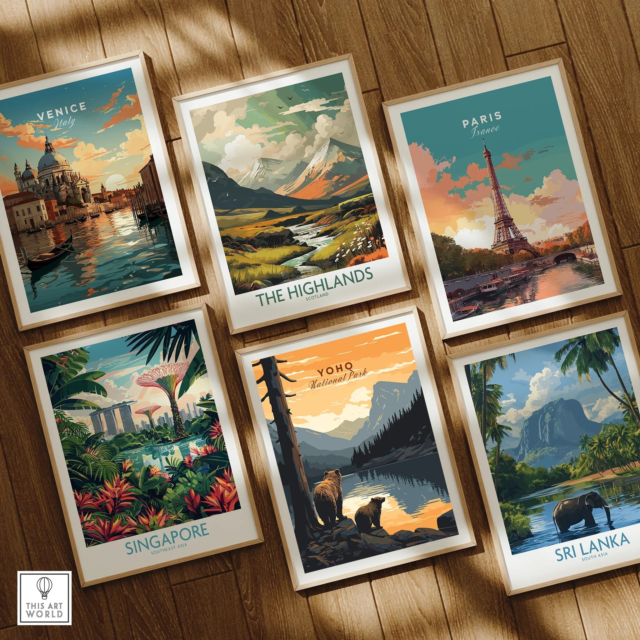 Set of six framed travel art prints on wooden floor, featuring Venice, Paris, The Highlands, Yoho National Park, Singapore, and Sri Lanka.