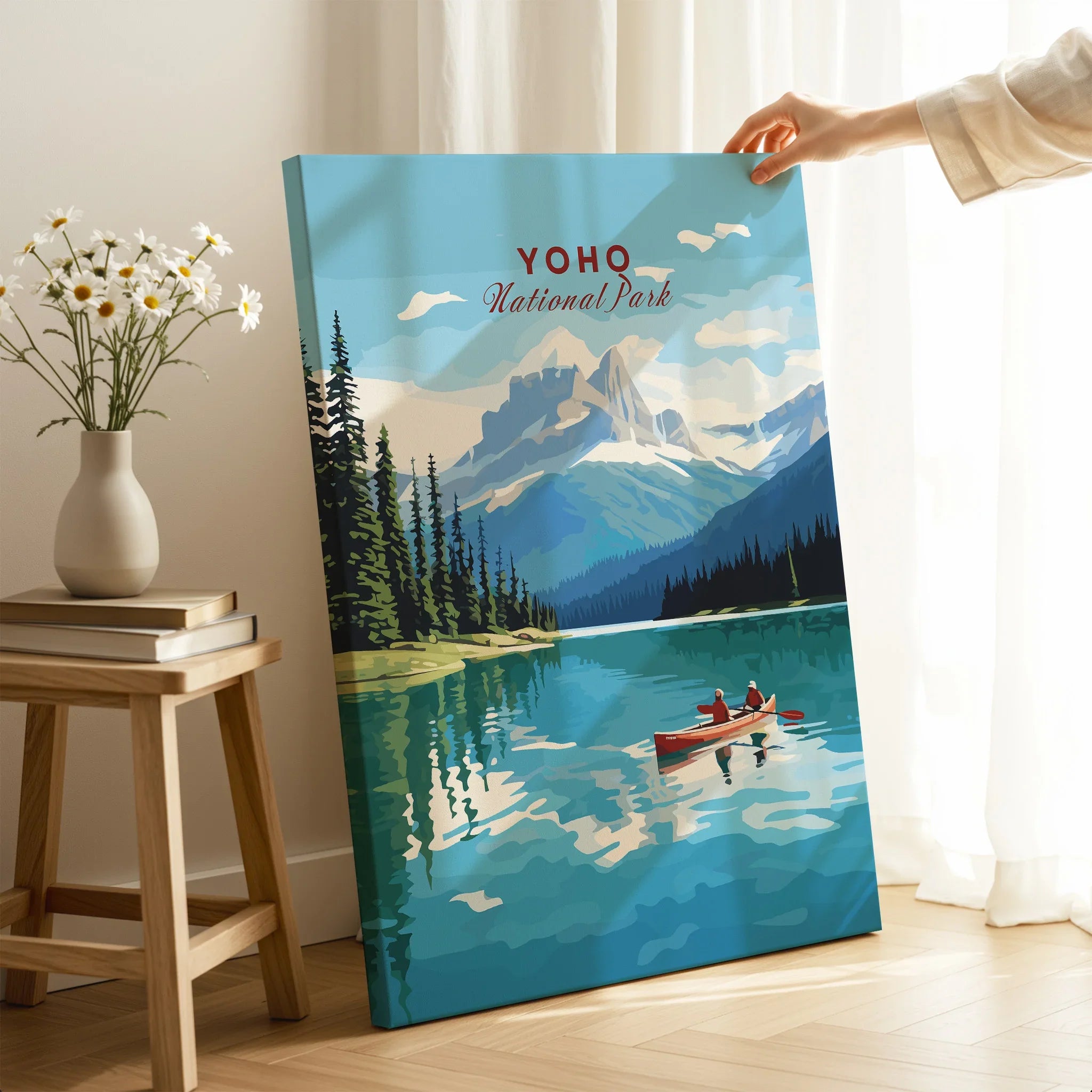 Yoho National Park travel poster print with mountain lake and canoe, hand holding canvas in cozy room
