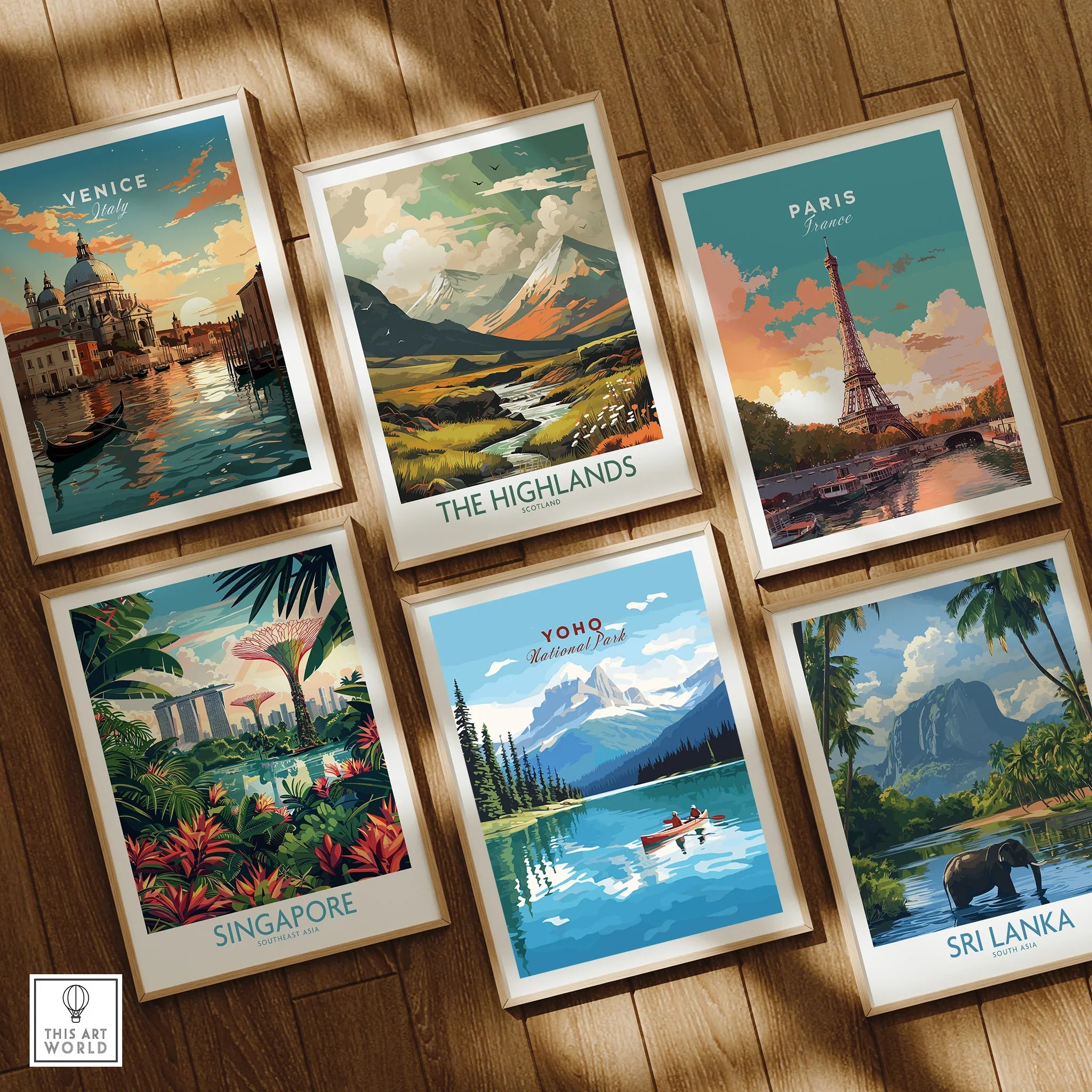 Set of six framed travel art prints featuring Venice, Paris, Highlands, Singapore, Yoho National Park, and Sri Lanka on wooden floor