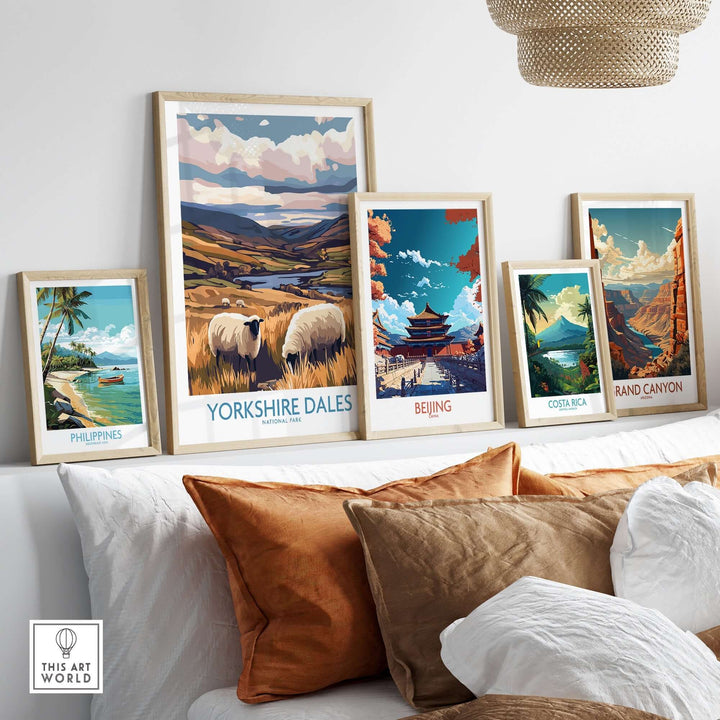 Framed posters of Yorkshire Dales, Beijing, Costa Rica, and Grand Canyon displayed on a shelf with decorative pillows.