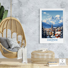 Zakopane travel poster displayed in a cozy interior, showcasing snowy mountains and a charming village scene.